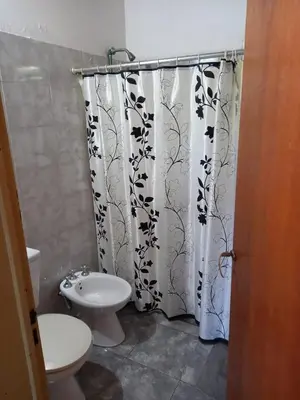 a bathroom with a toilet and a shower curtain at Cabaña Serrana in Santa Rosa de Calamuchita