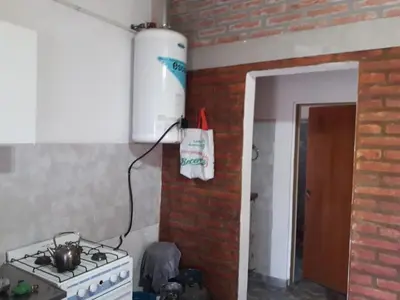 a kitchen with a stove and a brick wall at Cabaña Serrana in Santa Rosa de Calamuchita