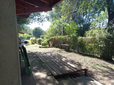 a wooden porch with a bench in a yard at Cabaña Serrana in Santa Rosa de Calamuchita