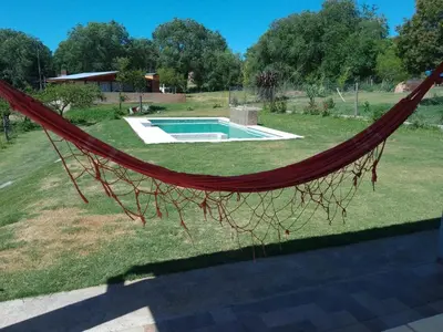 a hammock in a yard with a swimming pool at Casa Villa Amancay in Villa Amancay
