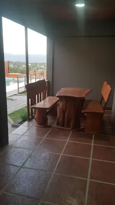 a table and two benches sitting next to a window at Alojamiento Tanti in Villa Santa Cruz del Lago