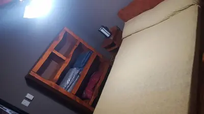 a room with a bed with a wooden book shelf at Alojamiento Tanti in Villa Santa Cruz del Lago