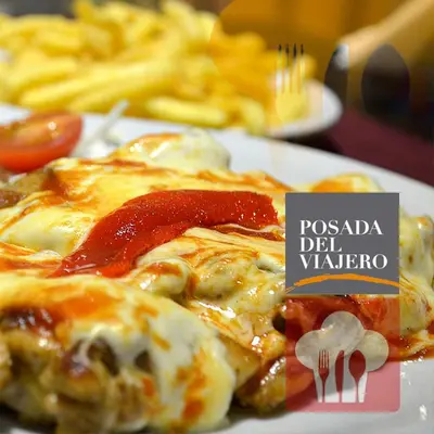 a plate of food with a pizza with sauce at Hotel La Posada del Viajero in Río Cuarto