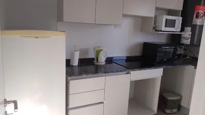 a small kitchen with a counter top with a microwave at Costanera Park in Cordoba