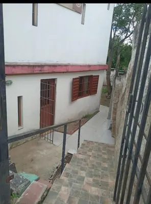 a white building with red windows and a stairway at El central in Tanti