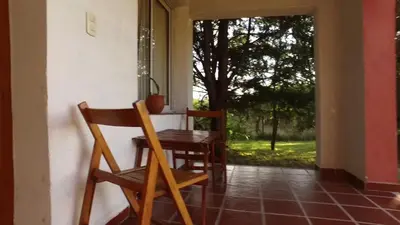 a table and chairs in a room with a window at Cortaderas Hotel de Campo Nono in Nono