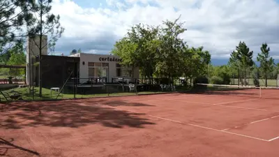 a tennis court in front of a building at Cortaderas Hotel de Campo Nono in Nono