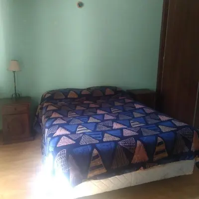 a bedroom with a bed with a blue and purple comforter at Tantanakuy in Villa General Belgrano