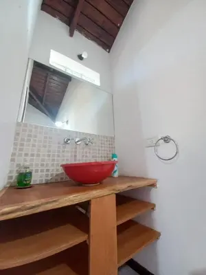 a bathroom with a red bowl on a counter with a mirror at Tantanakuy in Villa General Belgrano