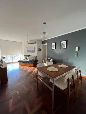 a living room with a table and chairs and a couch at Departamento Chacabuco in Cordoba