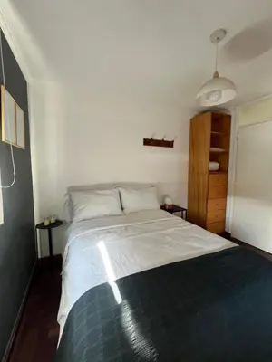 a bedroom with a large bed with white sheets at Departamento Chacabuco in Cordoba