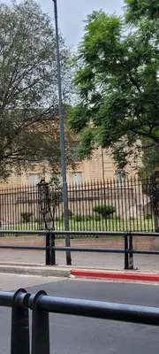 a fence on the side of a street with a pole at Departamento Chacabuco in Cordoba