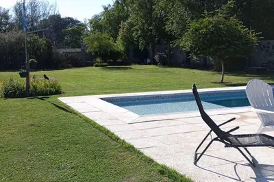 a chair sitting next to a swimming pool at Comodidad y espacio para relax in Falda del Carmen