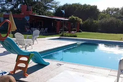 a backyard with a swimming pool with chairs and a slide at Comodidad y espacio para relax in Falda del Carmen