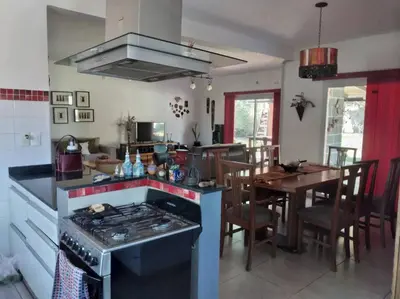 a kitchen with a stove and a dining room with a table at Comodidad y espacio para relax in Falda del Carmen