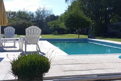 two white chairs sitting next to a swimming pool at Comodidad y espacio para relax in Falda del Carmen