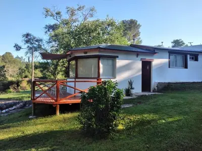 a small house with a porch in a yard at Cabaña a Arroyo Cristal in Tanti
