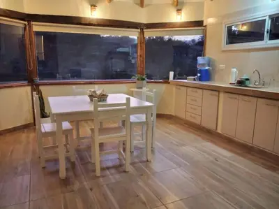 a kitchen with a white table and chairs in it at Cabaña a Arroyo Cristal in Tanti