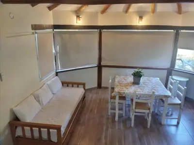 a room with a table and a couch and a table and chairs at Cabaña a Arroyo Cristal in Tanti