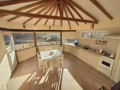 a kitchen with a table and some windows in it at Cabaña a Arroyo Cristal in Tanti