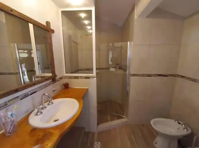 a bathroom with a sink and a shower and a toilet at Cabaña a Arroyo Cristal in Tanti