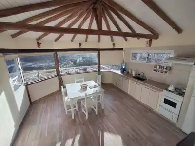 a kitchen with a table and chairs in a room at Cabaña a Arroyo Cristal in Tanti