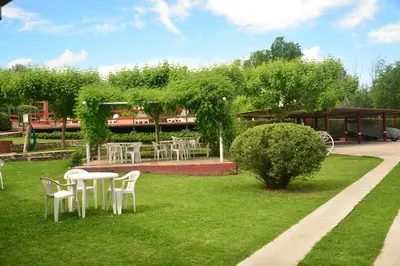 a group of tables and chairs in a park at Apart Cabañas La Estancia in Mina Clavero