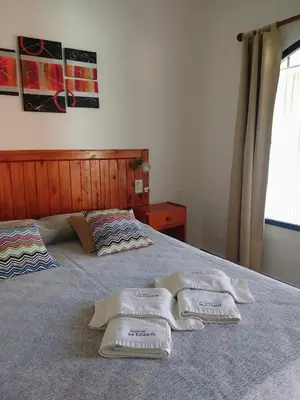 a bedroom with two towels on a bed at Apart Cabañas La Estancia in Mina Clavero
