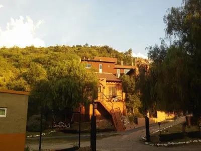 a house with a staircase in front of a building at La Loma Resort in Merlo