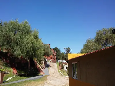 a dirt road with trees on the side of a building at La Loma Resort in Merlo