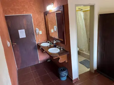a bathroom with two sinks and a mirror at La Loma Resort in Merlo