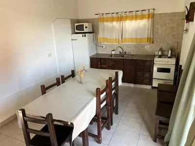 a kitchen with a white table and a white refrigerator at La Loma Resort in Merlo