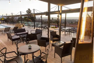 a restaurant with tables and chairs on a deck at Pinares Panorama Suites, Spa & Convention Center in Villa Carlos Paz