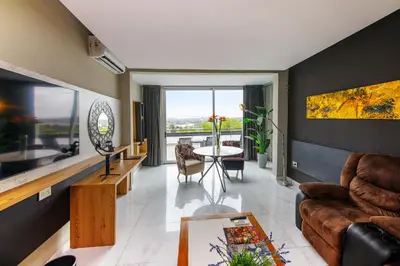 a living room with a couch and a table at Pinares Panorama Suites, Spa & Convention Center in Villa Carlos Paz