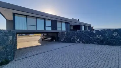 a building with a stone wall in front of it at Hermosa casa en Puerto del Águila, a orillas del Dique Los Molinos in La Estancia