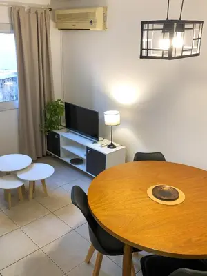 a living room with a table and a tv at THAYS 70. Hermoso Dpto en Parque de Las Tejas in Cordoba