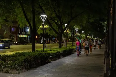 a group of people walking down a sidewalk at night at THAYS 70. Hermoso Dpto en Parque de Las Tejas in Cordoba