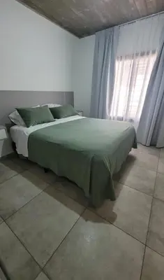 a bedroom with a green bed with a window at Casa Buda in Almafuerte