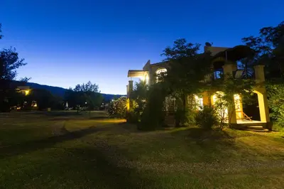 a house with lights on in a yard at night at Las Nubes Apart in Merlo