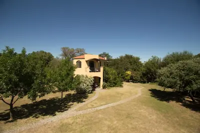 a house in the middle of a field with trees at Las Nubes Apart in Merlo
