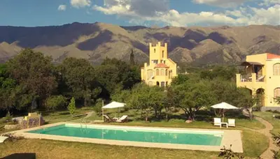 a swimming pool in front of a house with mountains at Las Nubes Apart in Merlo