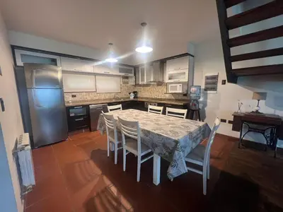 a kitchen with a table and chairs and a refrigerator at CASA VILLA LAGO AZUL CARLOS PAZ in Villa Carlos Paz