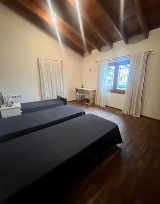 a bedroom with two beds and a desk and a window at CASA VILLA LAGO AZUL CARLOS PAZ in Villa Carlos Paz