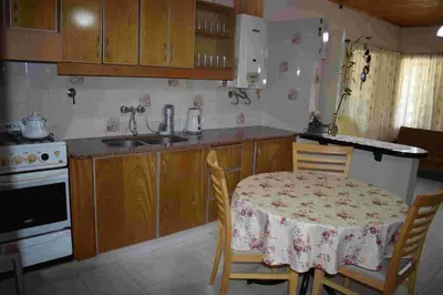 a kitchen with a table and chairs and a sink at El sueño de Norma in San Antonio de Arredondo