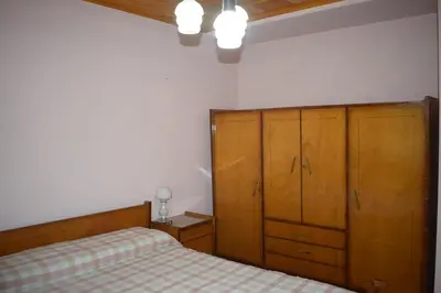 a bedroom with a bed and wooden cabinets at El sueño de Norma in San Antonio de Arredondo