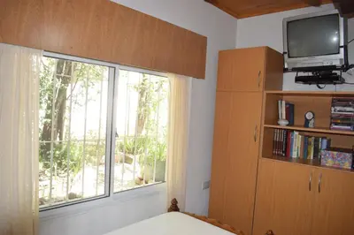 a bedroom with a large window and a television at El sueño de Norma in San Antonio de Arredondo