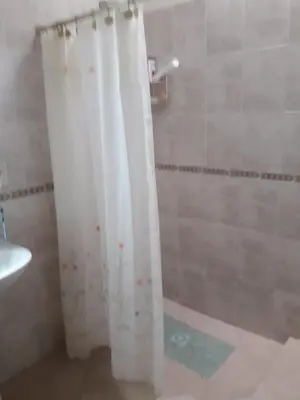 a bathroom with a shower with a white shower curtain at Andresito in Santa María