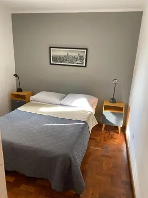 a small bedroom with a bed and two night stands at Cómodo departamento, excelente ubicacion in Cordoba