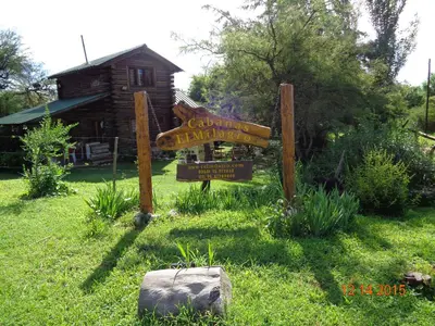a sign in the grass in front of a house at Cabañas El Milagro in San Roque