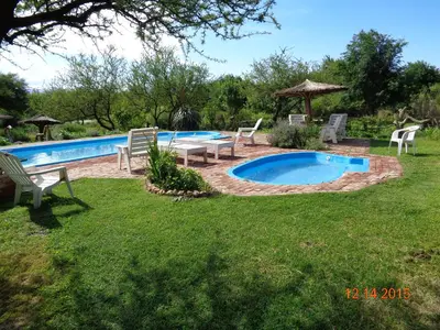 a pool with chairs and a table in a yard at Cabañas El Milagro in San Roque